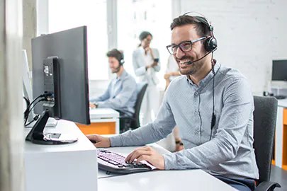 Mann mit Kopfhörern vor einem Computer